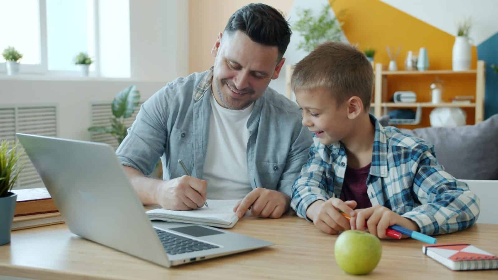 Father and son learning together on a laptop.